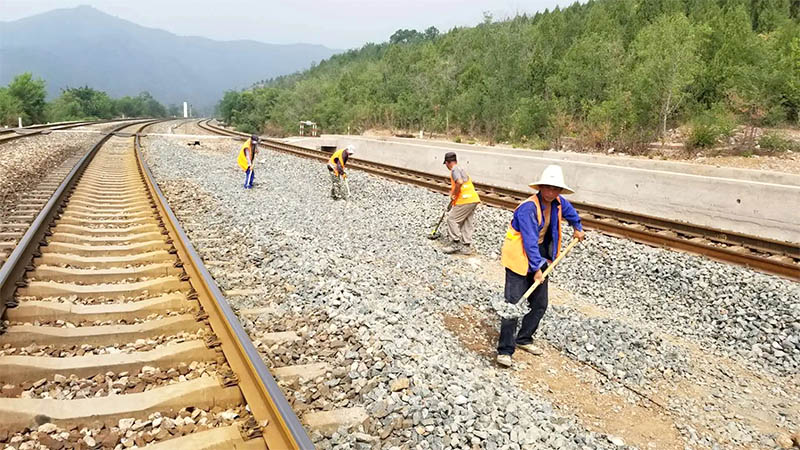 工人正在向鐵軌上填充道砟石 工人正在向鐵軌上填充道砟石